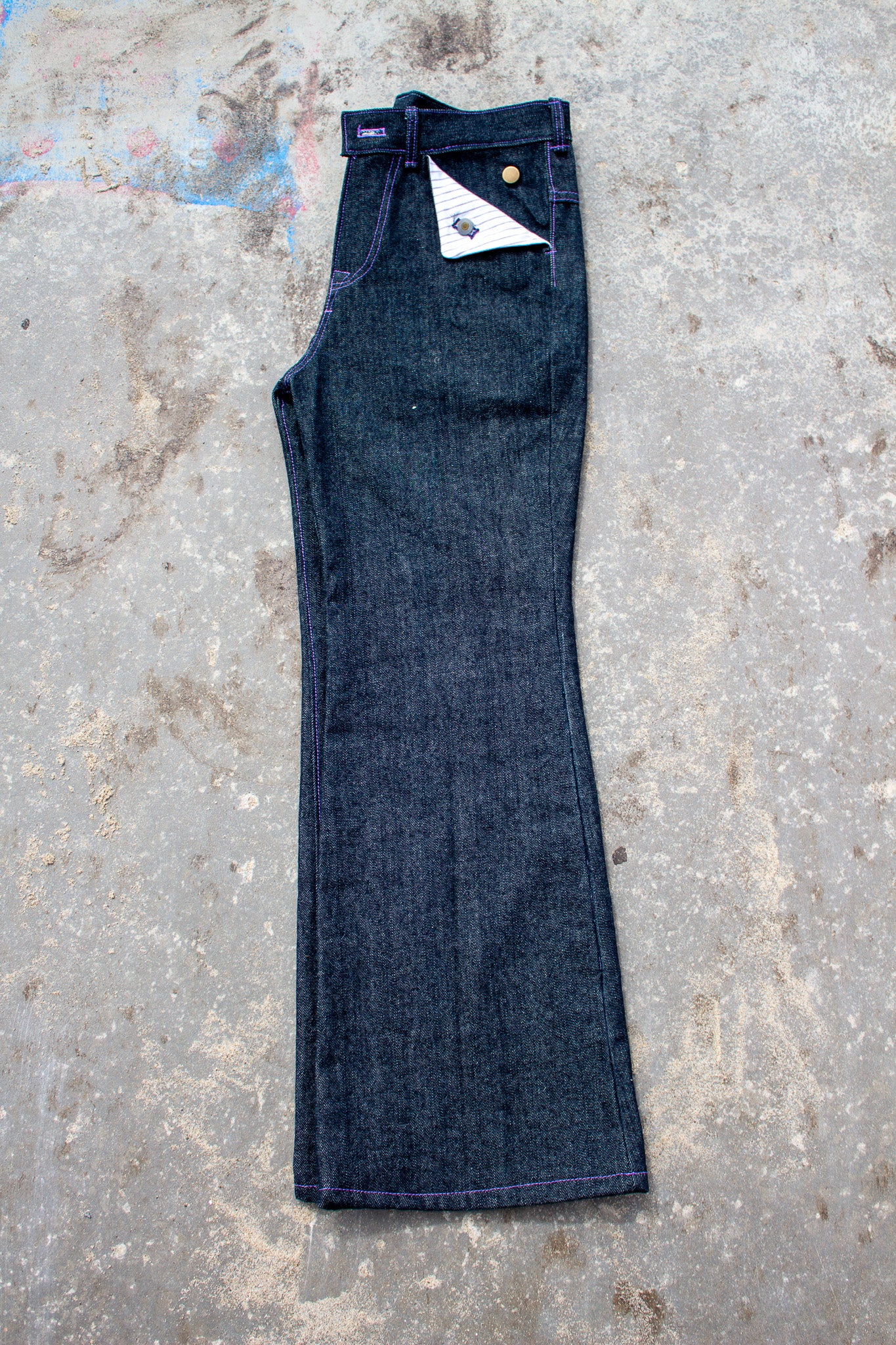 Pair of blue jeans on a textured concrete surface