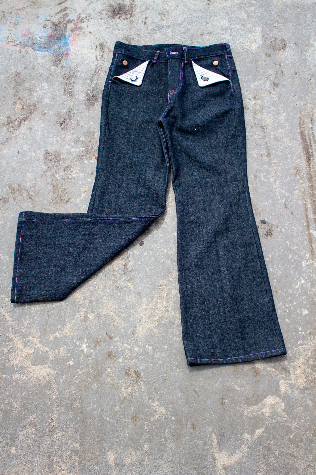 Pair of blue jeans on a textured gray surface
