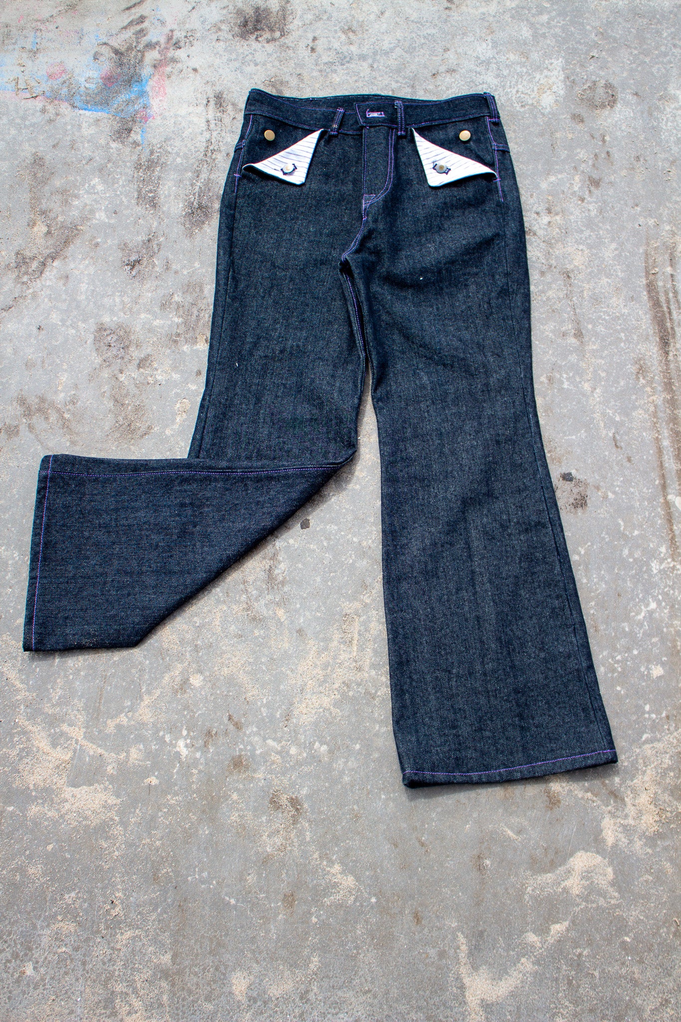 Pair of blue jeans on a textured gray surface