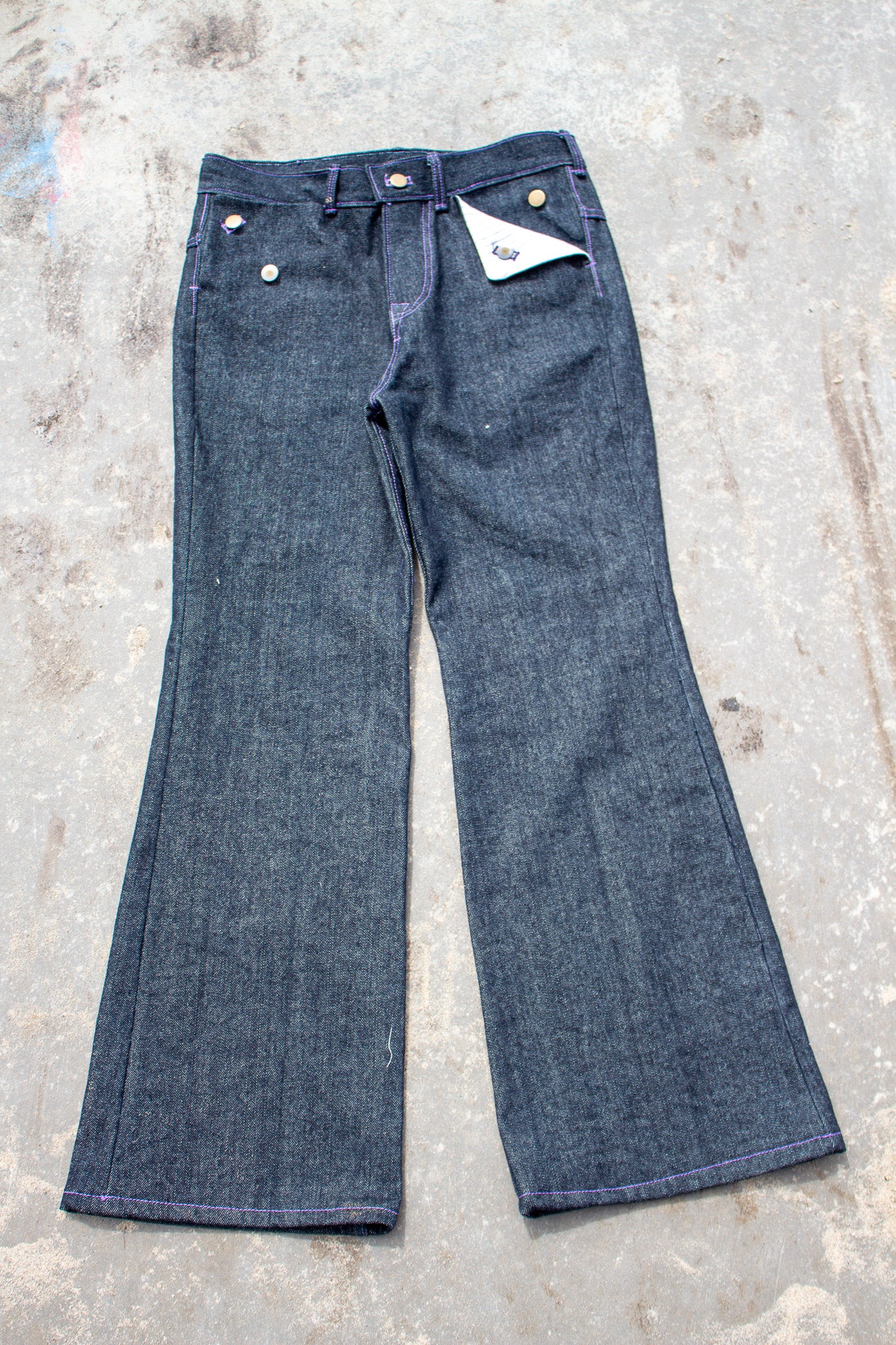 Pair of blue jeans on a textured gray surface