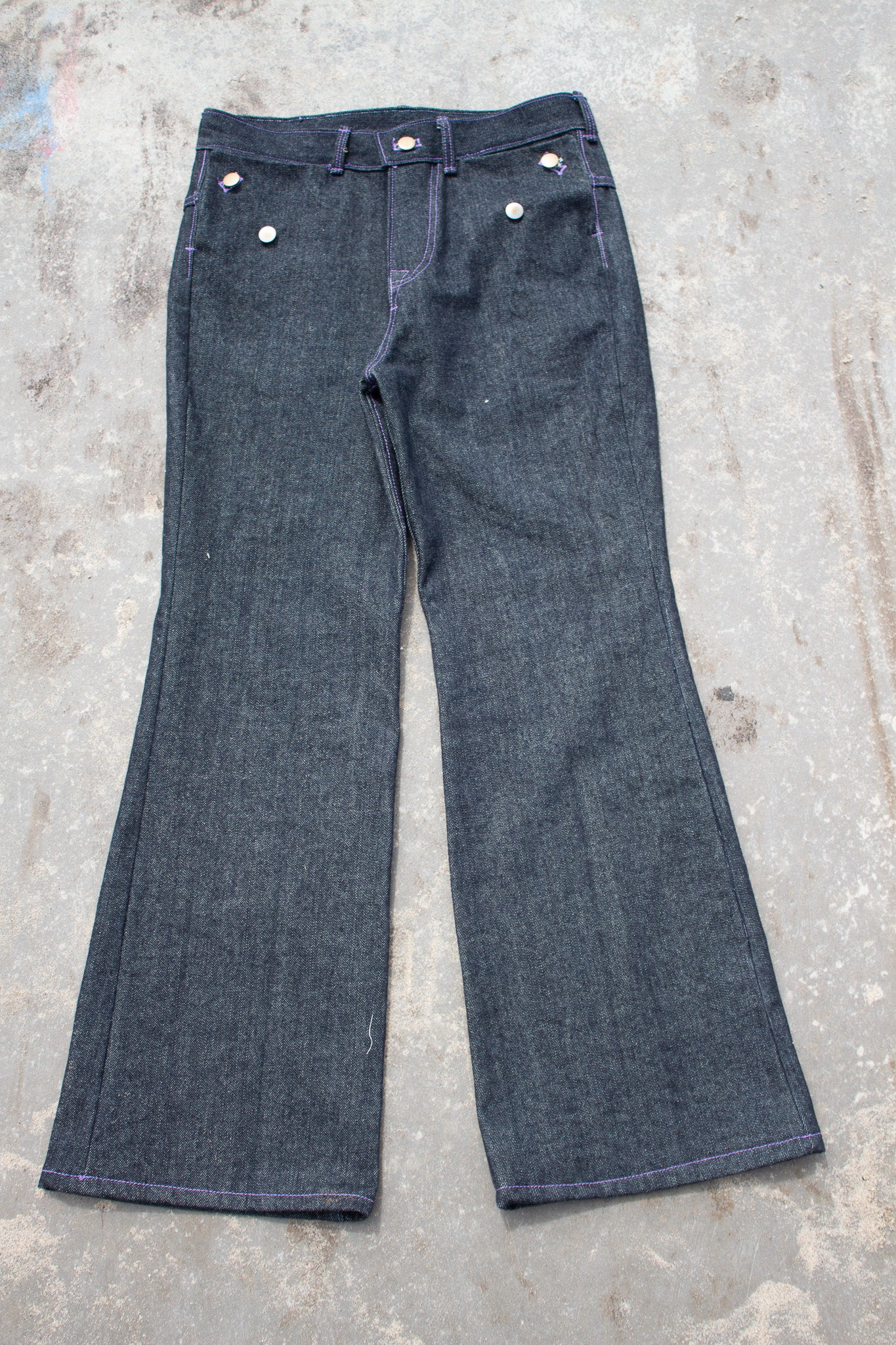 Pair of blue jeans on a concrete surface