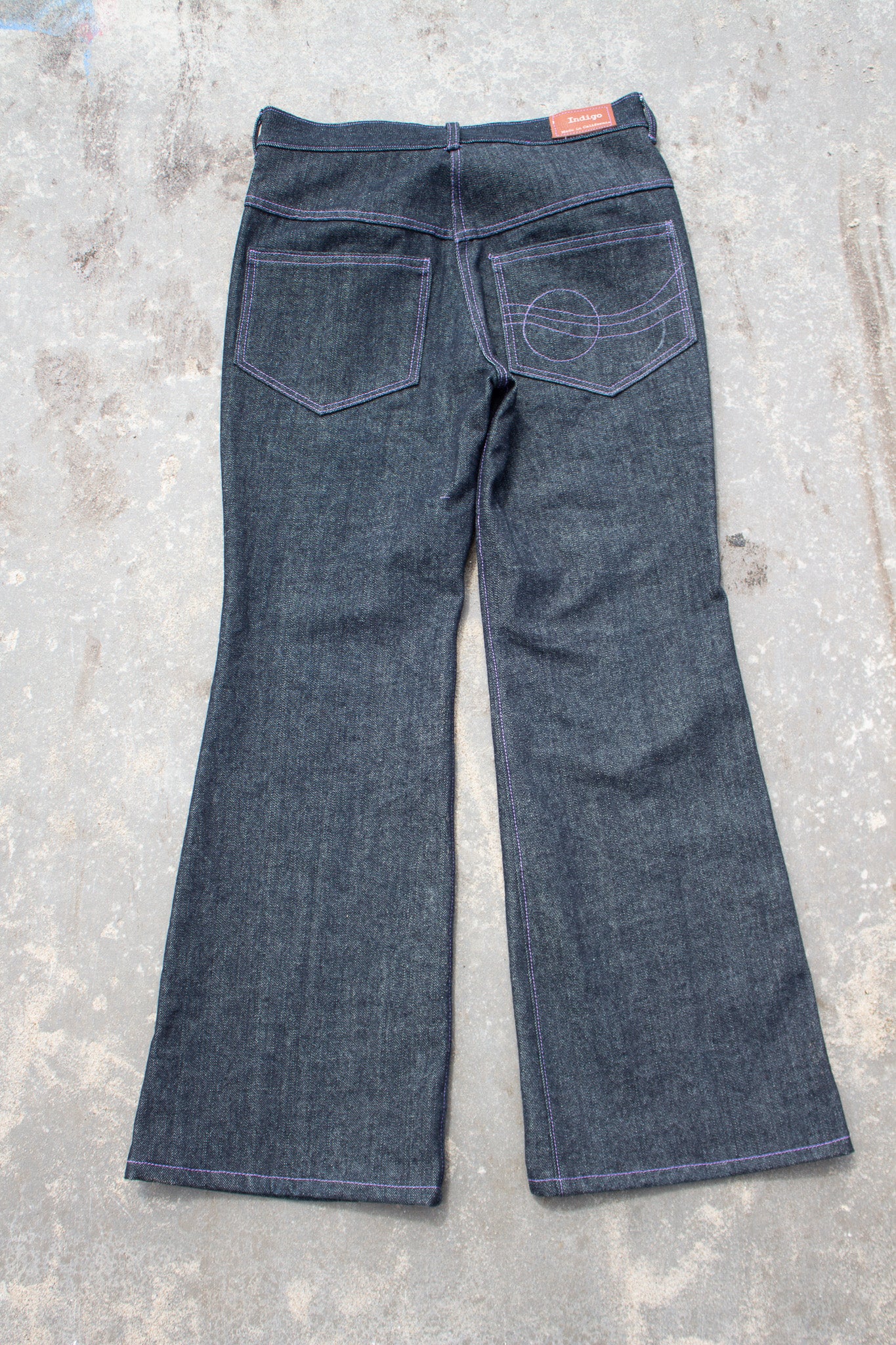 Pair of dark blue jeans on a concrete surface